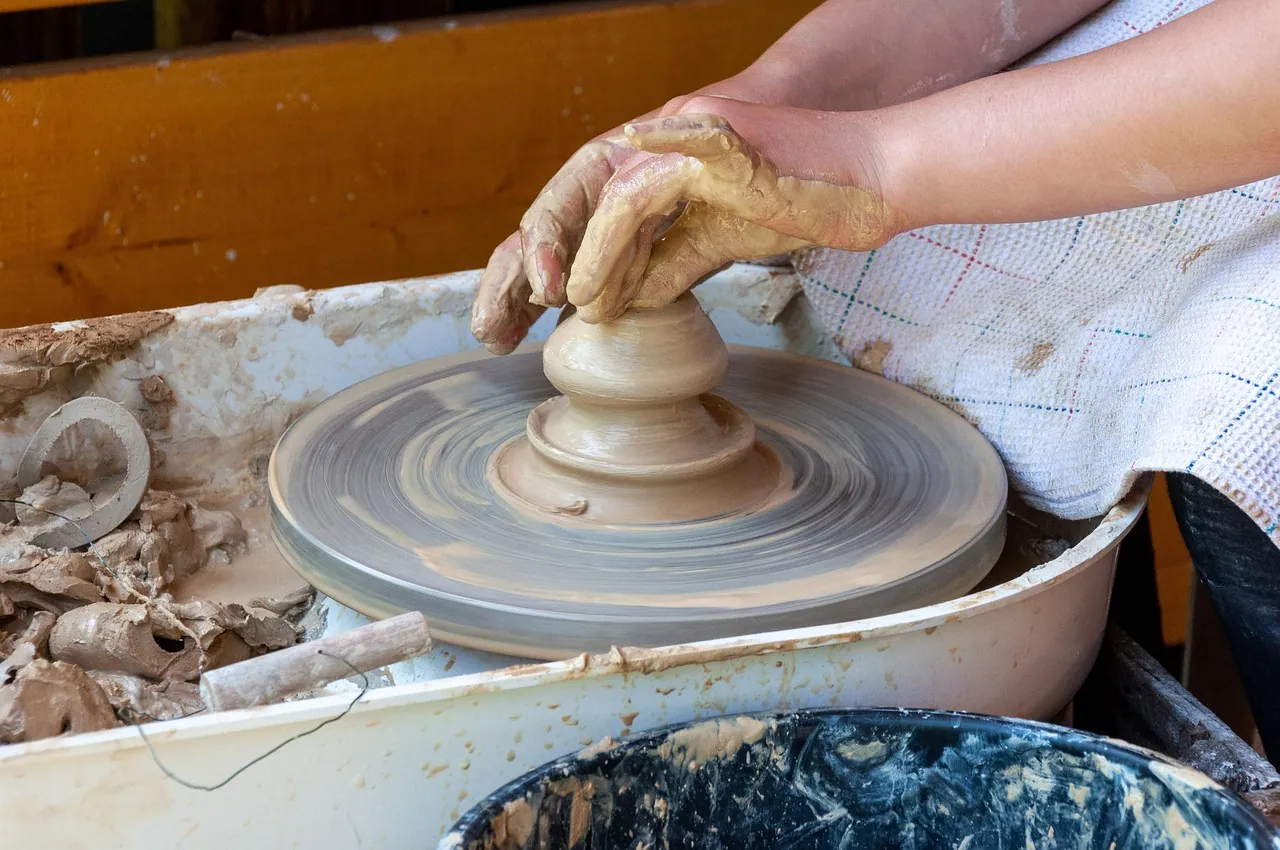 A potter shaping a bowl on a wheel.