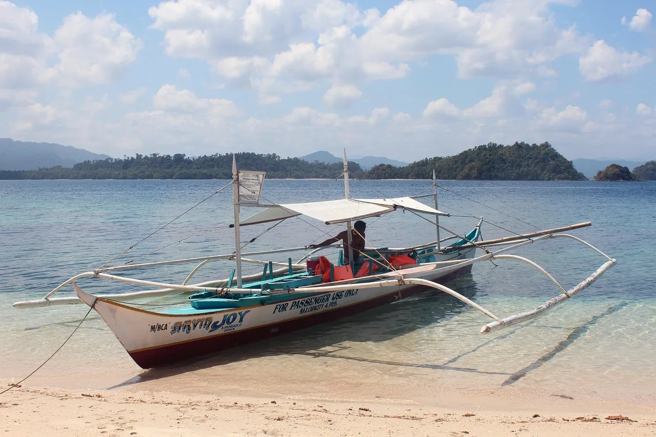A traditional outrigger boat on a quiet beach.