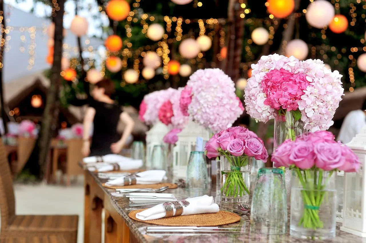 A wedding reception set with flowers and hanging lights.