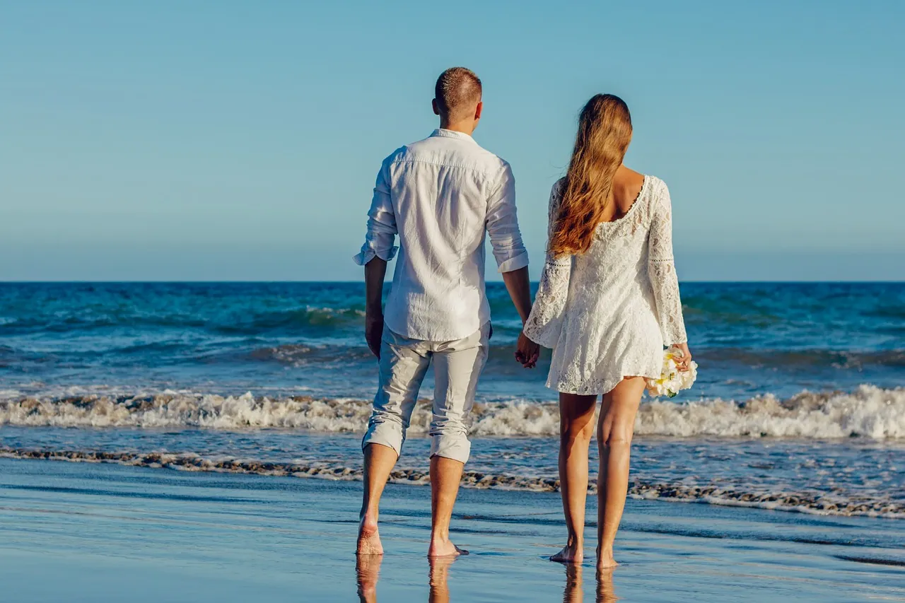 A couple walking on the beach after their ceremony.